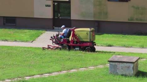 The-professional-worker-on-a-Gianni-Ferrari-lawn-mower-tractor-cutting-the-green-grass