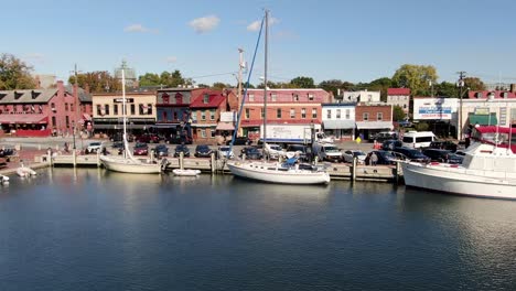 Slow-aerial-truck-shot-of-boats,-yachts-in-Ego-Alley-and-historic,-old-town-storefronts