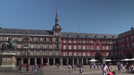 Slow-left-pan-over-Plaza-Mayor-in-Madrid-during-daytime-with-people-walking-through-frame