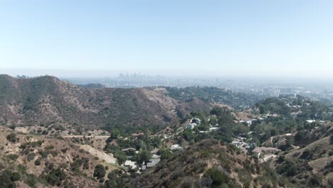 Leicht-Ansteigende-Luftneigung-über-Dem-Hollywood-Hill,-Wobei-Los-Angeles-Im-Dunst-Am-Horizont-Kaum-Sichtbar-Ist