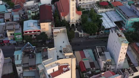 Vuelo-De-Drones-Por-La-Tarde-Sobre-Los-Tejados-Del-Distrito-De-Binh-Thanh,-Con-Una-Iglesia-Católica-En-Un-área-Densamente-Poblada-De-La-Ciudad-De-Ho-Chi-Minh-O-Saigon-Vietnam