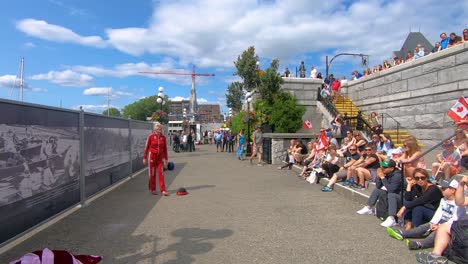 Crowds-Sitting-On-Steps-Watching-Street-Performer-At-Victoria-Harbour,-British-Columbia,-Canada