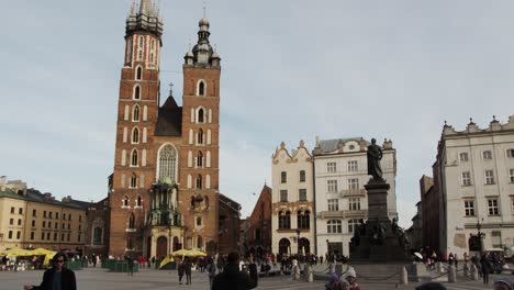 Crowds-sightseeing-around-Krakow-square-under-the-historic-old-town-church-building