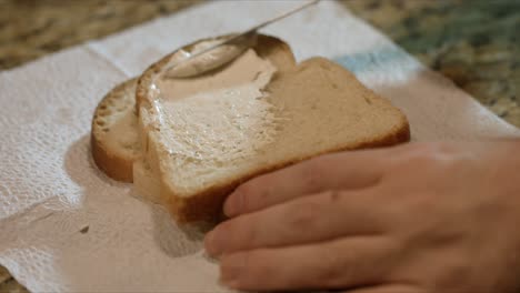 Close-up-spreading-cream-to-a-piece-of-bread