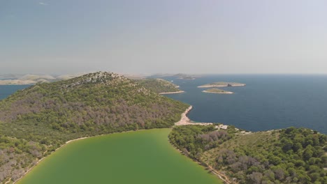 a-professional-looking-aerial-looking-over-a-green-salty-lake,-at-the-island-of-kornat,-at-the-adriatic-sea-in-south-croatia