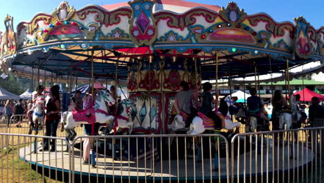 Merry-go-round-with-happy-children-at-Coos-County-Fair,-Summer-2019