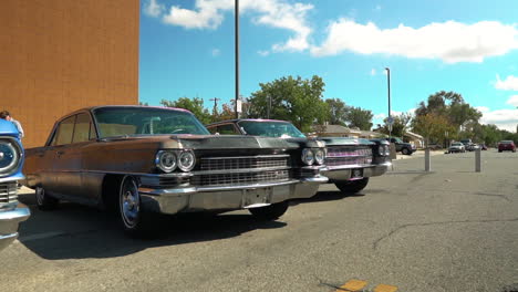 Row-of-Cadillac-DeVille-and-Eldorado-cars-parked-on-street,-reveal