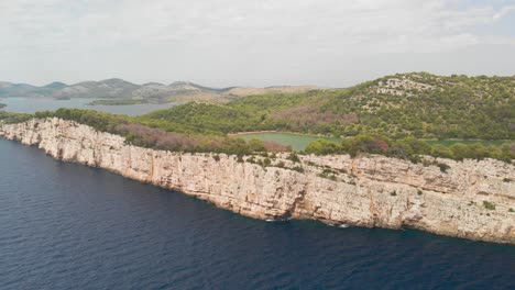 Eine-Professionell-Aussehende-Luftaufnahme-Der-Steilküste-Der-Insel-Kornat-In-Kroatien,-Die-Rückwärts-Fliegt-Und-Die-Landschaft-Zeigt
