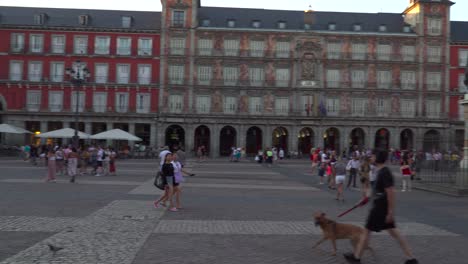 Quick-right-pan-over-Plaza-Mayor-with-tourists-walking-at-sunset