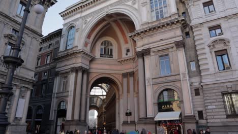 Eingang-Zur-Galleria-Vittorio-Emanuele-II-Von-Der-Piazza-Della-Scala-In-Mailand,-Italien,-Breites-Dolly-In-Nach-Oben-Geneigter-Aufnahme-Tagsüber-Mit-Gehenden-Menschen