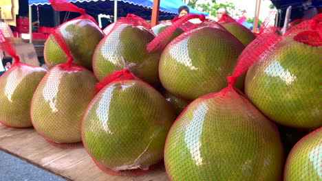 Malaysische-Pomelo-Früchte-Werden-Mit-Rotem-Kunststoff-Umwickelt