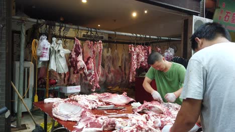 Xian,-China---August-2019-:-Two-men-workers-cutting-and-segregating-lamb-and-cow-carcass-meat-and-bones,-the-street-food-vendors-in-the-Muslim-quarter-of-Xian-town,-Shaanxi-Province
