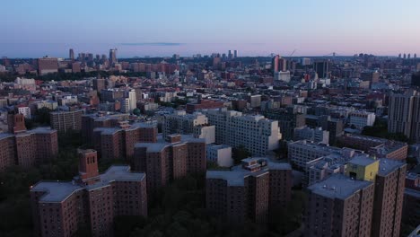 Slight-aerial-pan-down-over-housing-projects-from-skyline-over-Harlem-in-New-York-City-in-early-morning,-in-4K