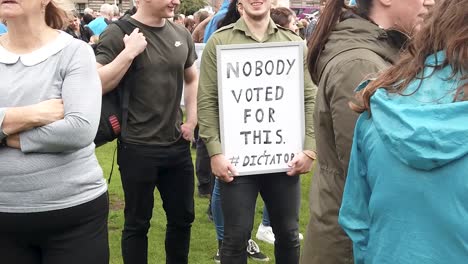 Slow-motion-of-a-young-Scottish-protester-with-a-message-on-a-whiteboard