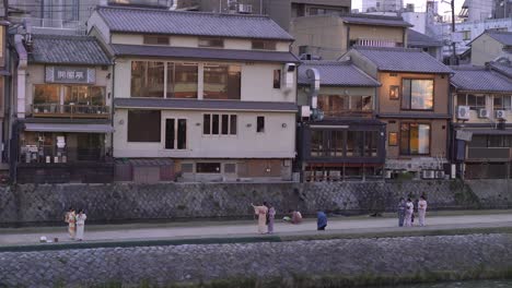 Kimono-Girls-Enjoy-Taking-Pictures-Against-Traditional-Buildings-In-Kyoto,-Japan---Wide-Shot