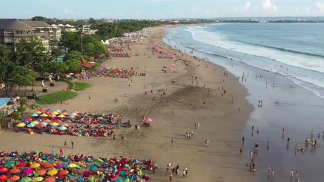 famous-double-six-beach-crowded-by-tourists,backward-fly-over-aerial,-Bali