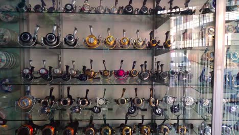Collection-of-fishing-reels-in-a-glass-cabinet-in-a-store