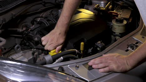 Removing-the-oil-cap-on-the-car-engine