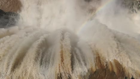 Extreme-close-up-top-view-of-powerful-raging-water-gushing-over-steep-vertical-cliff