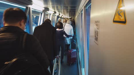 Passengers-queue-on-boarding-bridge-to-enter-aircraft-at-intl-airport
