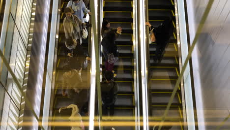 Top-down-view-of-people-riding-escalators-in-Shibuya-Station,-Japan