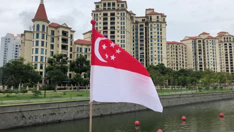 Singapur-Flagge-Mit-Wohngebäude-Im-Hintergrund