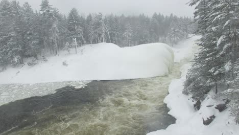 Langsam-Aufsteigende-Drohne-Filmt-Den-Waldrand-Mit-Schneebedeckten-Kiefern-Und-Fluss