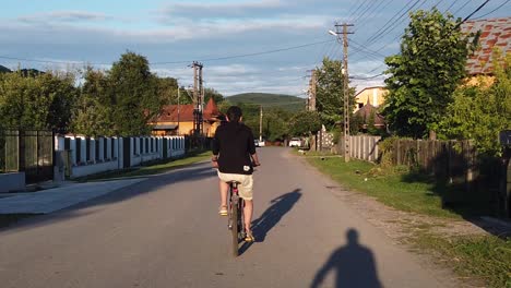 Moreni,-Rumänien---13.-Juli-2020:-Kerl-Mit-Schwarzem-Fahrrad-Auf-Einer-Landstraße-Bei-Sonnenuntergang,-Zeitlupe