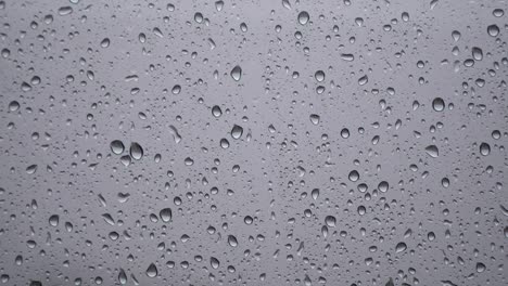 Regentropfen-Auf-Verschwommenem-Glasfenster---Regentagskonzept---Nahaufnahme