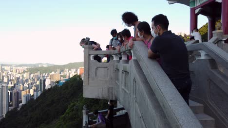 Tourists-taking-photos-of-Hong-Kong-skyline,-pan-shot-to-full-skyline-view