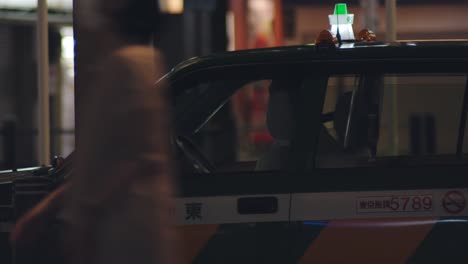 Conductor-Del-Taxi-Esperando-A-Los-Clientes-En-Kamata-Por-La-Noche-En-Tokio,-Japón
