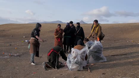Group-of-men-gather-in-preparation-of-Buddhist-Tibetan-sky-burial-in-desert-landscape