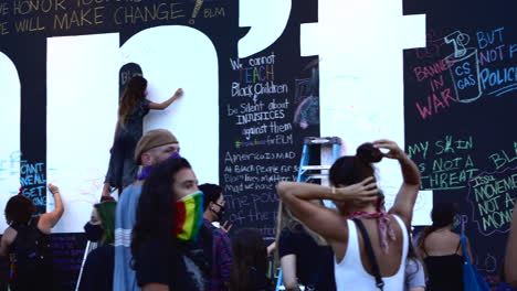 Crowd-writing-messages-on-wall-at-Chalk-the-Block-protest