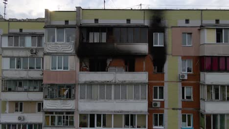 Luftaufnahme-Vor-Der-Fassade-Eines-Alten-Gebäudes-Mit-Verbrannten,-Verrußten-Wohnungen,-In-Einem-Erbärmlichen-Armutsviertel-Von-Kiew,-Bewölkter-Tag,-In-Kiew,-Ukraine-–-Aufgang,-Drohnenaufnahme