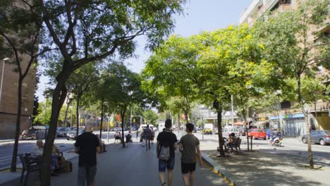 POV-walking-on-a-boulevard-of-Barcelona-with-people-and-entering-on-the-metro