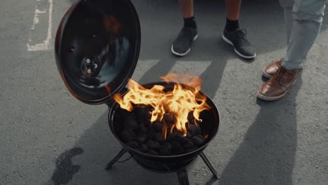 Group-of-Friends-Lighting-a-Small-Black-Charcoal-Grill