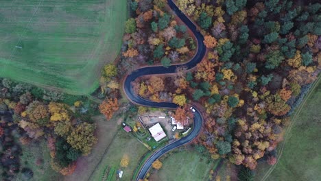 Cinematic-Aerial-View-of-Lonely-White-Car-Moving-on-Curvy-Road,-Colorful-Autumn-Landscape-of-Scenic-Valley,-Top-Down-Drone-Shot