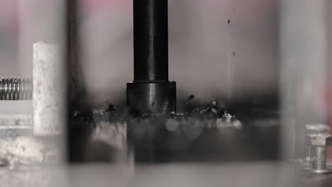 Drill-Bit-Drilling-Hole-Through-Metal-Plate---close-up,-slow-motion