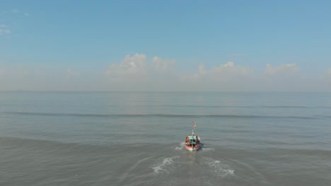 Fallende-Drohnenaufnahme-Eines-Kleinen-Bunten-Indischen-Fischerbootes,-Das-Aufs-Meer-Hinausfährt
