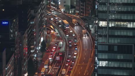 Carretera-Curva-Con-Tráfico-Durante-La-Hora-Pico-En-El-Paisaje-Urbano-De-Shibuya-En-Tokio,-Japón-Por-La-Noche