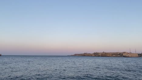 Beautiful-Panning-Timelapse-over-Valletta-Break-Water-durin-Dusk-in-Malta---Blue-Hour