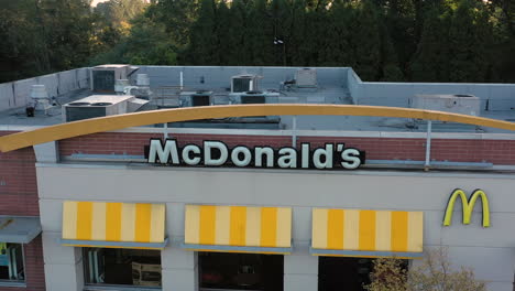Rising-drone-orbit-of-the-front-exterior-facade-of-a-McDonald's-restaurant-store-building