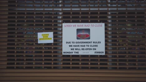 Two-covid-signs-on-a-shop-shutter-during-the-Tier-4-lockdown-in-Scotland