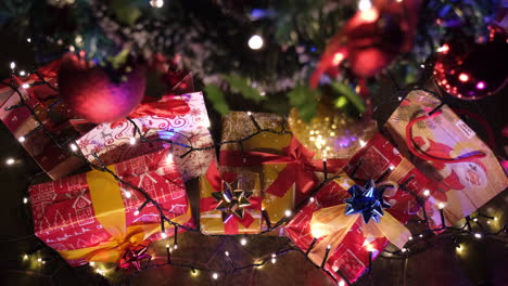 Christmas-gifts-and-decorated-tree-with-colorful-light-during-Xmas-night-celebration