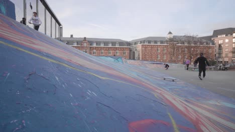 Skateboarder-tries-to-perform-skateboard-trick,-fails-and-almost-falls,-unsuccessful-jump-attempt-in-skate-park,-Brussels,-Belgium