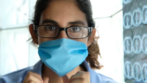 portrait-close-up-female-doctor-puts-on-protective-Face-Mask