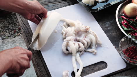 Manos-Del-Chef-Limpiando-Y-Recortando-Calamares,-Ingredientes-De-Preparación-De-Alimentos-En-La-Mesa