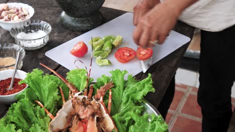 Person-Cutting-Tomato-with-Sharp-Knife-on-a-White-Board-to-decorate-Lobster-dish