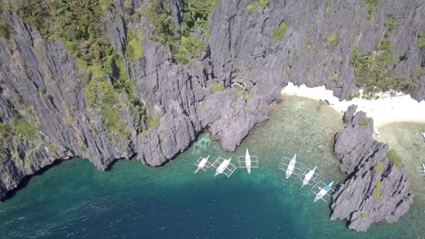 4K-Luftdrohnenansicht-Von-Banca-Booten-Auf-Den-Philippinen-Auf-Der-Miniloc-Insel-Und-Dem-Geheimen-Lagunenstrand