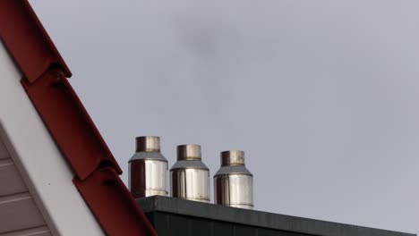 Smoke-Coming-Out-Of-The-Chimney-Pipes-On-The-House-Roof---close-up